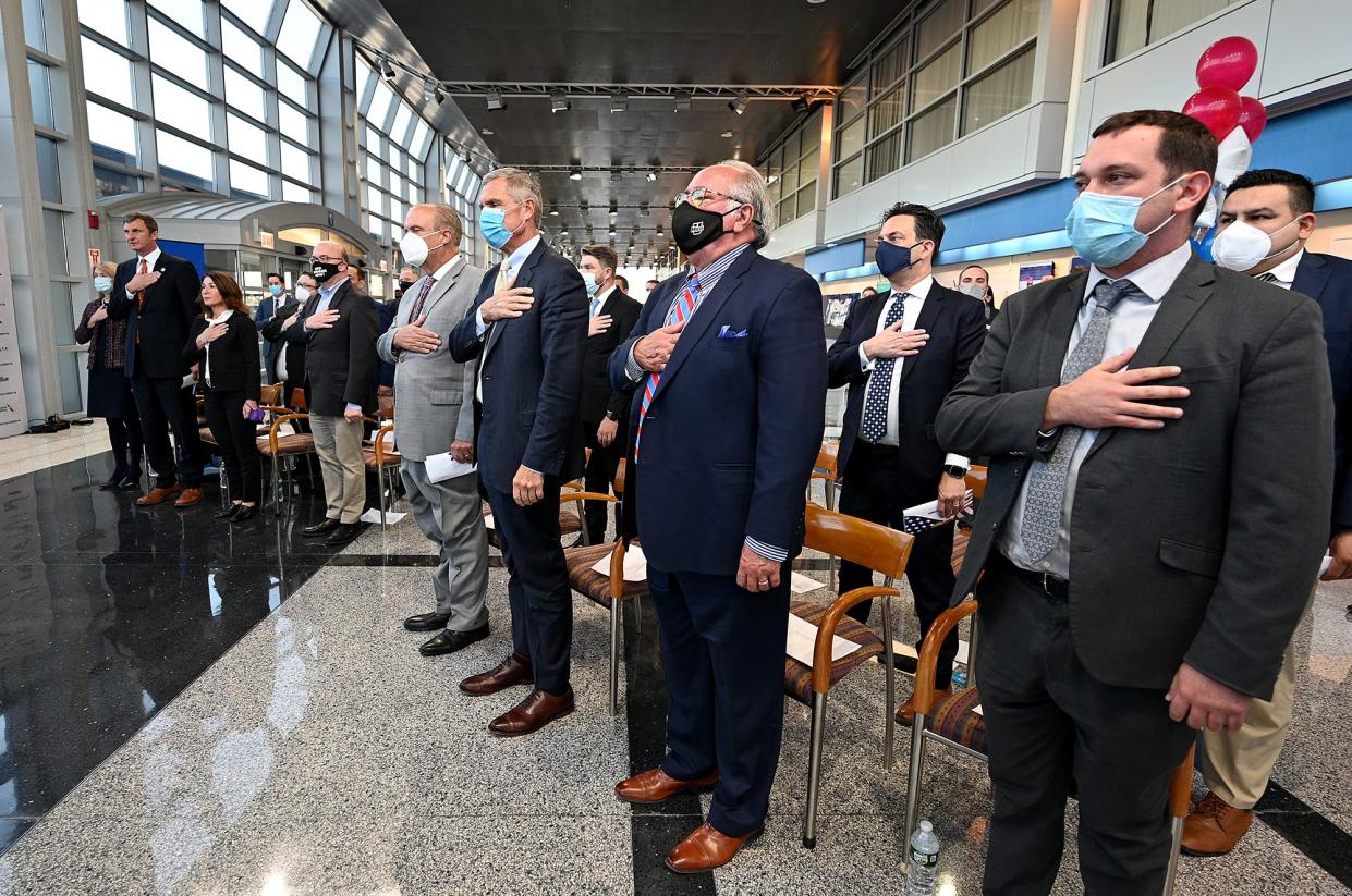 State and local officials salute the flag during a Massport ceremony at Worcester Airport.