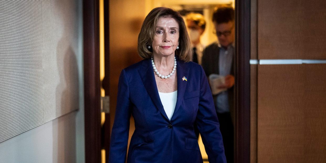 Nancy Pelosi walking in a dark blue suit.