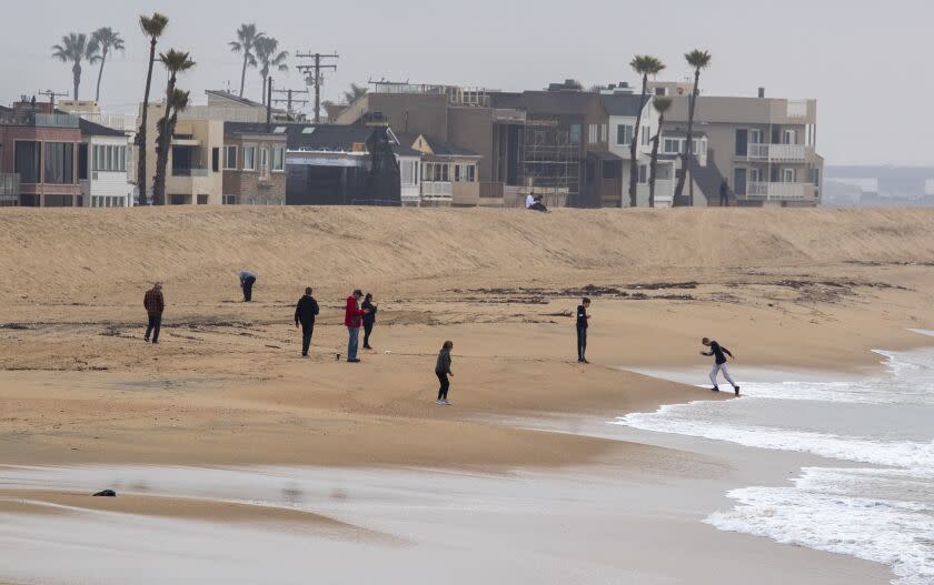 Orange County, CA - December 23: Beachcombers along the shore at Seal Beach are out for the large King Tide hitting the coast this week on Friday, Dec. 23, 2022 in Orange County, CA. (Brian van der Brug / Los Angeles Times)