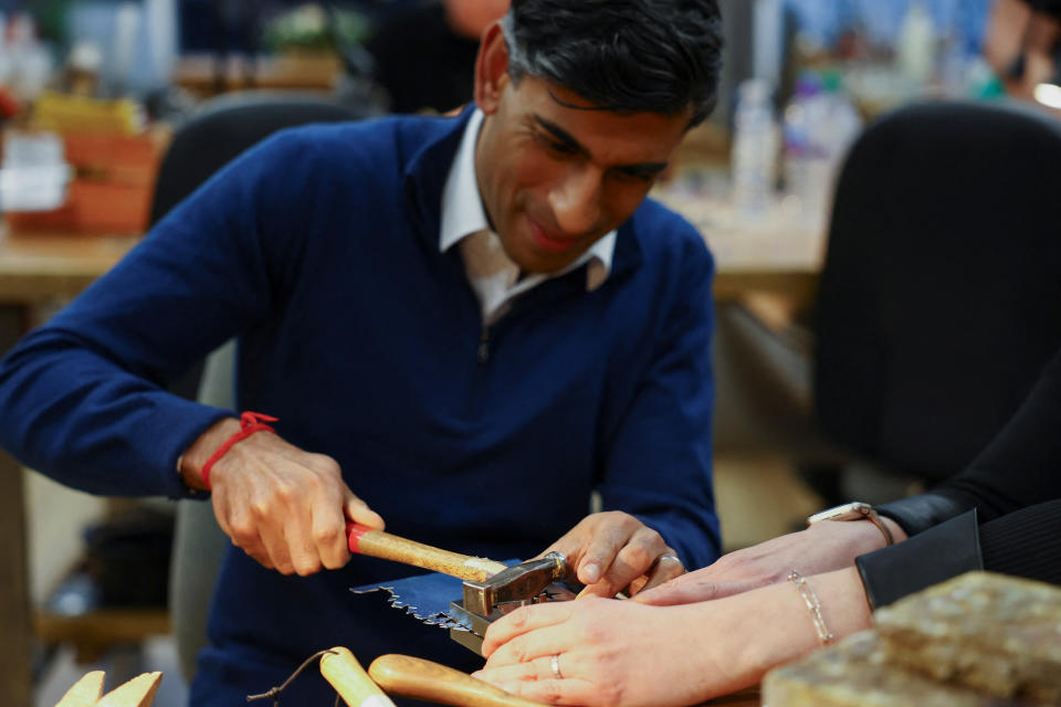 Prime Minister Rishi Sunak next to Emma White, hammers a piece of jewellery during a meeting with small business owners (Molly Darlington/PA Wire)