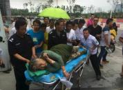 A woman is helped as she is sent to hospital after being pulled out by a diver from the sunken ship in Jianli, Hubei province, China, June 2, 2015. Rescuers are working to save five more passengers trapped inside the hull of a passenger ship that capsized on China's Yangtze River with 458 people on board, the official People's Daily said on its microblog on Tuesday. A 65-year-old woman was pulled alive from the wreck, although state media had earlier given her age as 85. (REUTERS/Stringer)