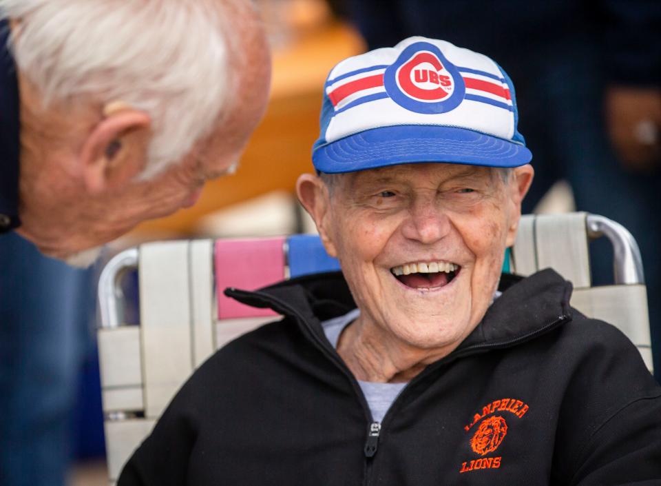 Arlyn Lober laughs as he reminisces with lifelong friends Art and Jean Spiegel as family and friends gather for a driveway birthday party to celebrate Lober's 97th birthday in Springfield, Ill., Saturday, May 8, 2021. Lober, a World War II veteran that fought in the Battle of the Bulge, was a teacher at Lanphier High School for 33 years and for 22 of those years was a successful basketball coach for the Lions that took five teams to the state tournament.