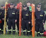 In a major security exercise, firefighters with stretchers are lined up to hear orders before they comb nearby woods for fleeing illegal foreigners in Jasce, Poland, on Wednesday, April 23, 2014. The three-day exercise is to test the response of internal security services to emergency situations and is held at a time of conflict between Poland’s two neighbors, Ukraine and Russia. (AP Photo/Czarek Sokolowski)