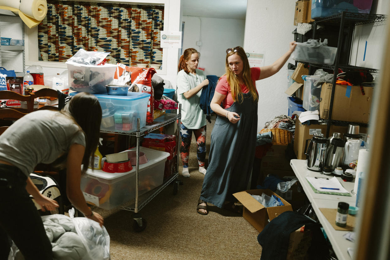 Cassy Leach, a volunteer, gathers clothes at a facility run by the nonprofit Mobile Integrated Navigation Team, a homeless outreach group, in Grants Pass, Ore., March 18, 2024. (Mason Trinca/The New York Times)