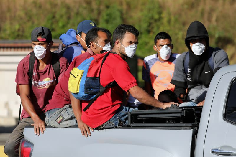 People traveling in a truck wear protective masks as they pass through a checkpoint after the start of quarantine in response to the spreading of coronavirus disease (COVID-19) in Caracas