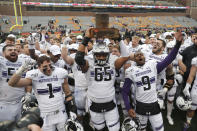 FILE - In this Nov. 30, 2019, file photo, Northwestern celebrates with the Land Of Lincoln trophy after beating Illinois 29-10 in an NCAA college football game in Champaign, Ill. Big Ten is going to give fall football a shot after all. Less than five weeks after pushing football and other fall sports to spring in the name of player safety during the pandemic, the conference changed course Wednesday, Sept. 16, 2020, and said it plans to begin its season the weekend of Oct. 23-24. (AP Photo/Charles Rex Arbogast, File)