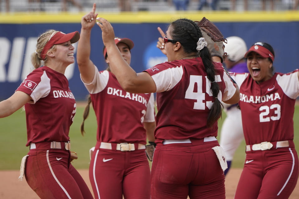 Oklahoma pitcher Giselle Juarez (45) celebrates with teammates after they defeated James Madison in an NCAA Women's College World Series softball game Monday, June 7, 2021, in Oklahoma City. Oklahoma moves onto the championship finals series. (AP Photo/Sue Ogrocki)