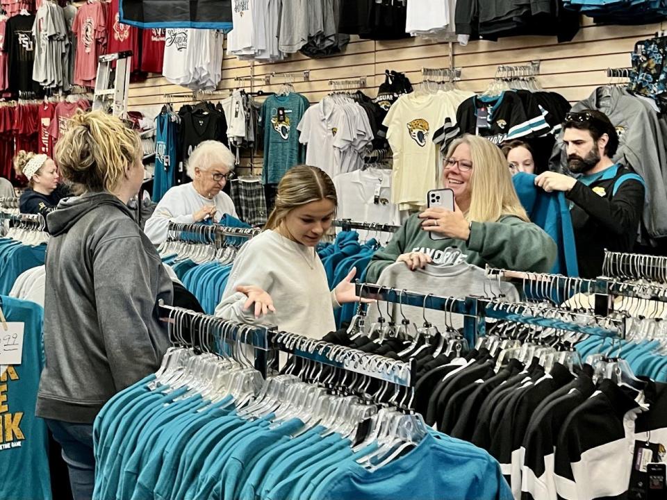 Customers at Sports Mania in Jacksonville Beach look through its assortment of Jaguars merchandise.