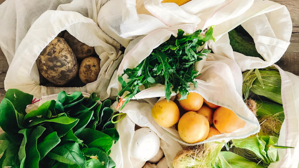 Reusable cotton bags filled with fruit and vegatables