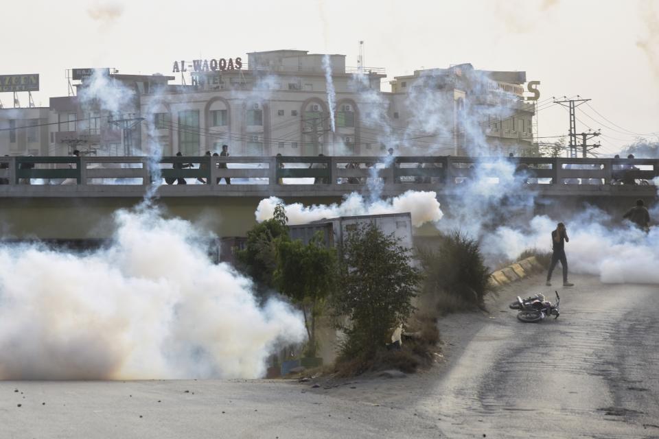 Police fire tear gas shell to disperse supporters of former Pakistani Prime Minister Imran Khan's party, 'Pakistan Tehreek-e-Insaf' during a protest to condemn a shooting incident on their leader's convoy, in Rawalpindi, Pakistan, Friday, Nov. 4, 2022. Khan who narrowly escaped an assassination attempt on his life the previous day when a gunman fired multiple shots and wounded him in the leg during a protest rally is listed in stable condition after undergoing surgery at a hospital, a senior leader from his party said Friday. (AP Photo/W.K. Yousafzai)