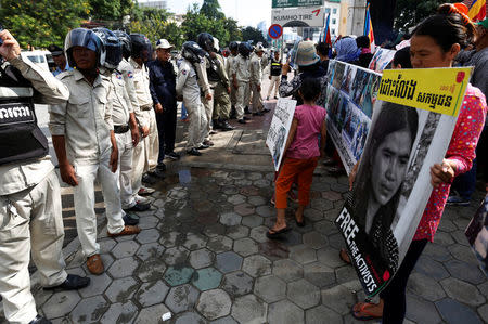 District Security Guards line up as protesters hold banners and a portrait of land activist Tep Vanny during a demonstration in front of the Municipal Court of Phnom Penh, Cambodia, September 19, 2016. REUTERS/Samrang Pring