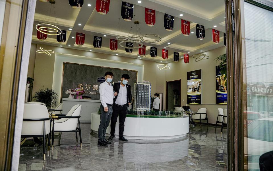 Two young men stand in a showroom for a new Hampton hotel complex