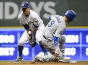 Jul 21, 2018; Milwaukee, WI, USA; Los Angeles Dodgers catcher Yasmani Grandal (9) advances to second base after a wild pitch as Milwaukee Brewers shortstop Tyler Saladino (13) fields the ball in the sixth inning at Miller Park. Mandatory Credit: Benny Sieu-USA TODAY Sports