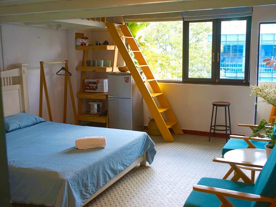 Room with a mezzanine level and a small balcony with views of the street below