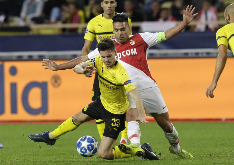 Dortmund's Julian Weigl, left, fights for the ball with Monaco forwarder Radamel Falcao during the Champions League group A soccer match between AS Monaco and Borussia Dortmund, in Monaco, Tuesday, Dec. 11, 2018. (AP Photo/Claude Paris)