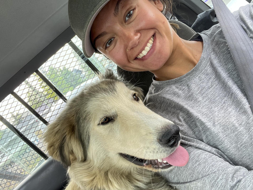 This photo provided by Dr. Michelle Tuma, a veterinarian in the Northern Territories capital of Yellowknife, Canada, and member of Veterinarians Without Borders, shows herself with her foster dog, Thor, July 28, 2023. Tuma has spent the past month trying to help families flee the wildfires in Canada with their pets, reunite with them or keep tabs on animals left behind. (Michelle Tuma via AP)