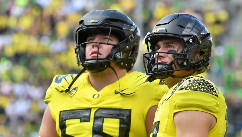 Oregon quarterback Bo Nix (10) and offensive lineman Jackson Powers-Johnson (58) watch a replay from the sidelines as they compete against Portland State during a game, Saturday, Sept. 2, 2023, in Eugene, Ore.