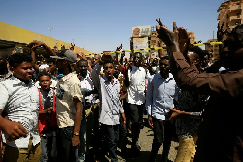 People shouting slogan gather near the scene of an explosion that targeted the motorcade of Sudan's Prime Minister Abdalla Hamdok near the Kober Bridge in Khartoum