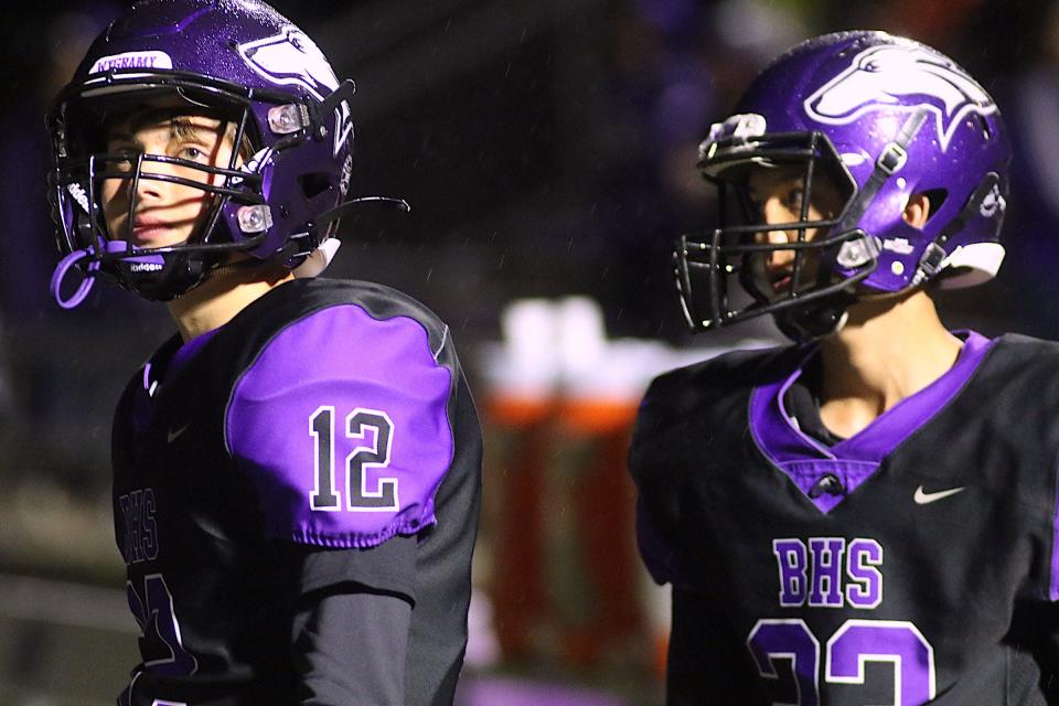 Burlington's Brennen Winke (12) and Christian Snyder (23) watch the game from the sidelines earlier this season