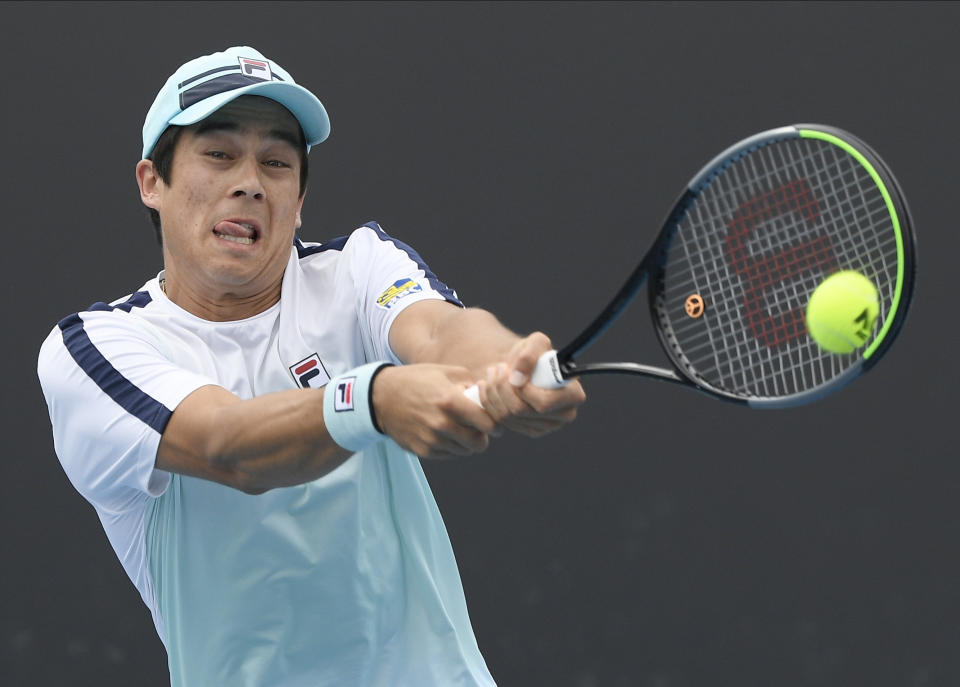 United States' Mackenzie McDonald makes a backhand return to Croatia's Borna Coric during their second round match at the Australian Open tennis championship in Melbourne, Australia, Thursday, Feb. 11, 2021.(AP Photo/Andy Brownbill)