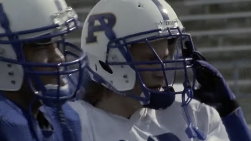 Two NFL players wearing helmets on the field, a still from Friday Night Lights