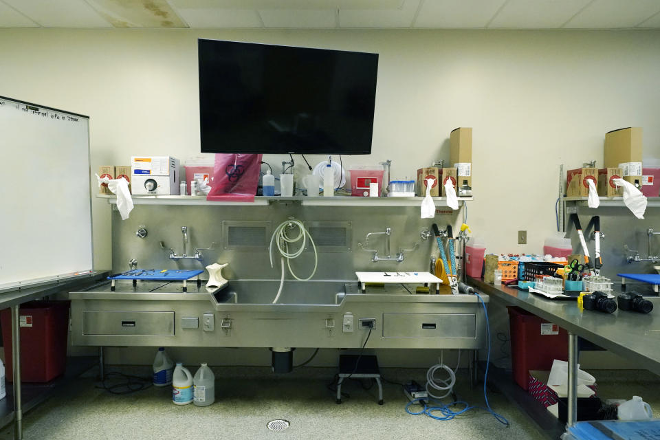 A computer monitor and a dry erase easel are among the tools pathologists have use of in each of the autopsy bays in the Mississippi Crime Laboratory in Pearl, Miss., Aug. 26, 2021. (AP Photo/Rogelio V. Solis)