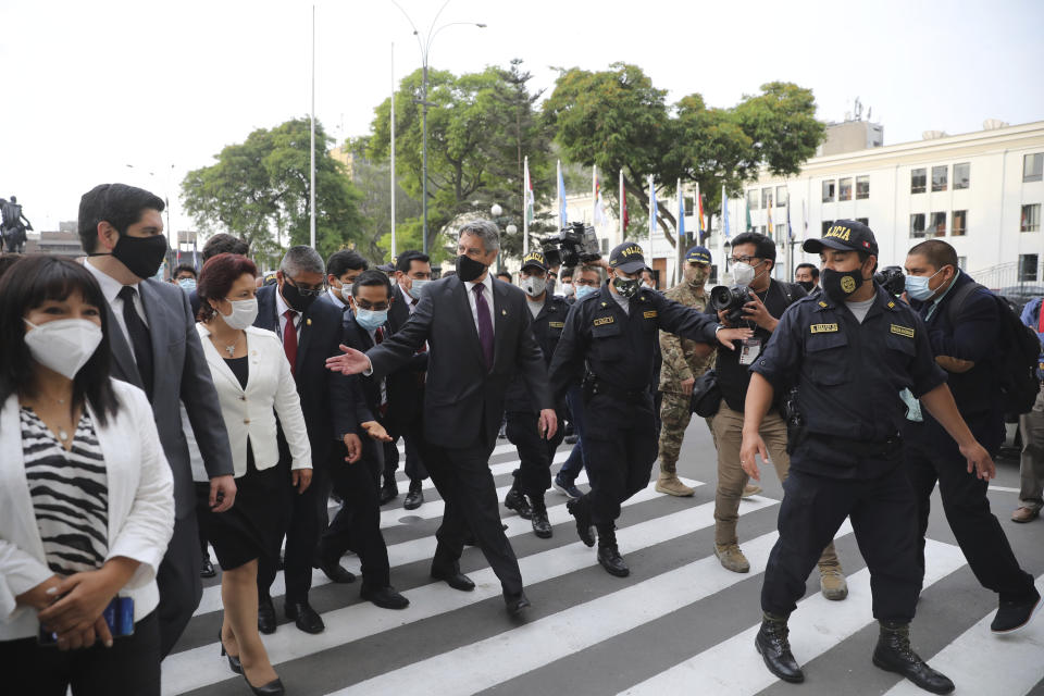 Peru's new interim President Francisco Sagasti, center, walks outside Congress after he was designated by lawmakers to lead the nation, in Lima, Peru, Monday, Nov. 16, 2020. Congress chose Sagasti to become the nation's third president in the span of a week after Congress ousted Martin Vizcarra and the following protests forced his successor Manuel Merino to resign. (AP Photo/Rodrigo Abd)