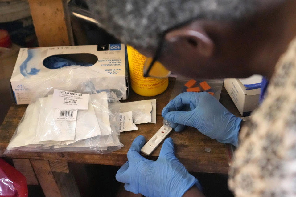 Traditional healer Florence Khoza reads results from a rapid HIV blood test in Bushbuckridge, South Africa, Thursday, May 9, 2024. While South Africa has made strides in fighting HIV, prevalence remains high and stigma is widespread in many communities with researchers hoping the relationship of trust between villagers and traditional healers will bring more people to HIV testing, counseling and care. (AP Photo/Themba Hadebe)