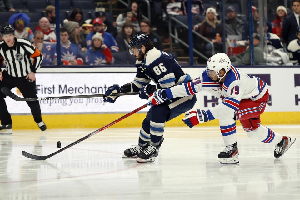 Columbus Blue Jackets forward Kirill Marchenko (86) chases the puck in ront of New York Rangers defenseman K'Andre Miller, right, during the second period of an NHL hockey game in Columbus, Ohio, Sunday, Feb. 25, 2024. (AP Photo/Paul Vernon)