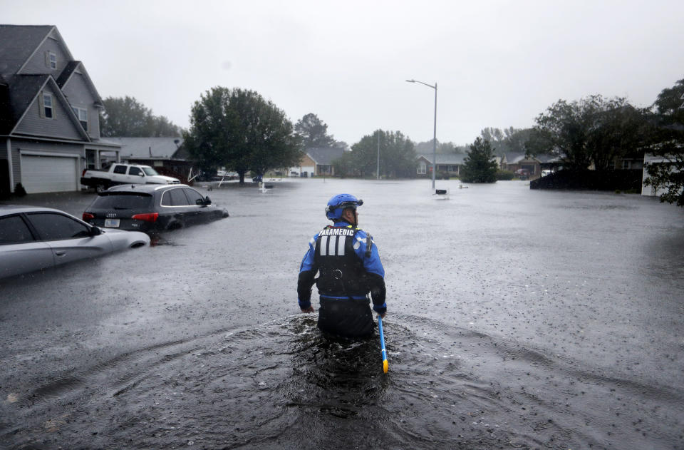 FILE - In this Sunday, Sept. 16, 2018 file photo, a member of the North Carolina Task Force urban search and rescue team wades through a flooded neighborhood looking for residents who stayed behind as Florence continues to dump heavy rain in Fayetteville, N.C. According to data released by the National Oceanic and Atmospheric Administration on Tuesday, May 4, 2021, the new United States normal is not just hotter, but wetter in the eastern and central parts of the nation and considerably drier in the West than just a decade earlier. (AP Photo/David Goldman)