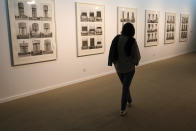 A visitor looks at artworks by German artists Bernd and Hilla Becher while visiting a 19th and 20th-century American and European minimalist and conceptual masterpieces show at the Tehran Museum of Contemporary Art in Tehran, Iran, Tuesday, Aug. 2, 2022. Some of the world’s most prized works of contemporary Western art have been unveiled for the first time in decades — in Tehran. (AP Photo/Vahid Salemi)