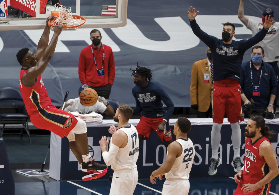 New Orleans Pelicans forward Zion Williamson (1) dunks next to Memphis Grizzlies center Jonas Valanciunas (17) and guard Desmond Bane (22) during the fourth quarter of an NBA basketball game in New Orleans, Saturday, Feb. 6, 2021. (AP Photo/Derick Hingle)