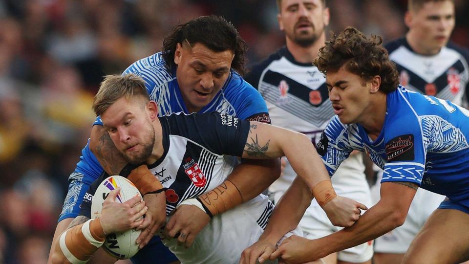 Mike Cooper of England is tackled by Josh Papalii and Chanel Harris-Tavita of Samoa during the Rugby League World Cup semi-final match between England and Samoa