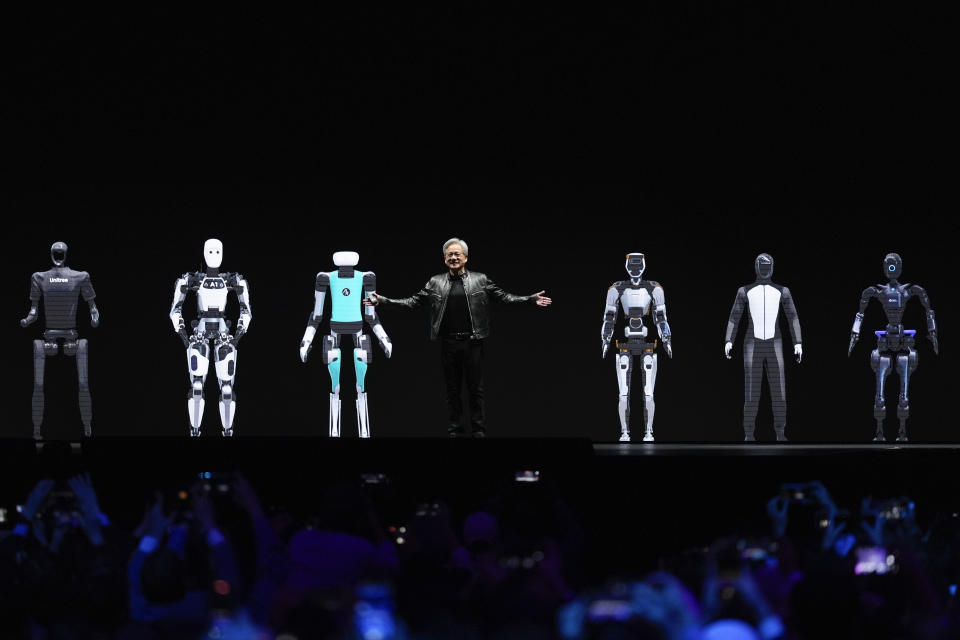 CEO Jensen Huang gestures while standing amidst images of robots to conclude his keynote address at Nvidia GTC in San Jose, Calif., Monday, March 18, 2024. (AP Photo/Eric Risberg)