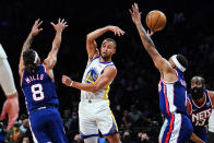 Golden State Warriors' Stephen Curry (30) passes away from Brooklyn Nets' Patty Mills (8) and Bruce Brown (1) during the first half of an NBA basketball game Tuesday, Nov. 16, 2021 in New York. (AP Photo/Frank Franklin II)