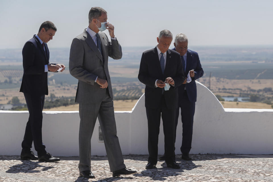 From left to right: Spain's Prime Minister Pedro Sanchez, Spain's King Felipe VI, Portugal's President Marcelo Rebelo de Sousa and Portugal's Prime Minister Antonio Costa adjusts their face masks during a ceremony to mark the reopening of the Portugal/Spain border in Elvas, Portugal, Wednesday, July 1, 2020. The border was closed for three and a half months due to the coronavirus pandemic. (AP Photo/Armando Franca)