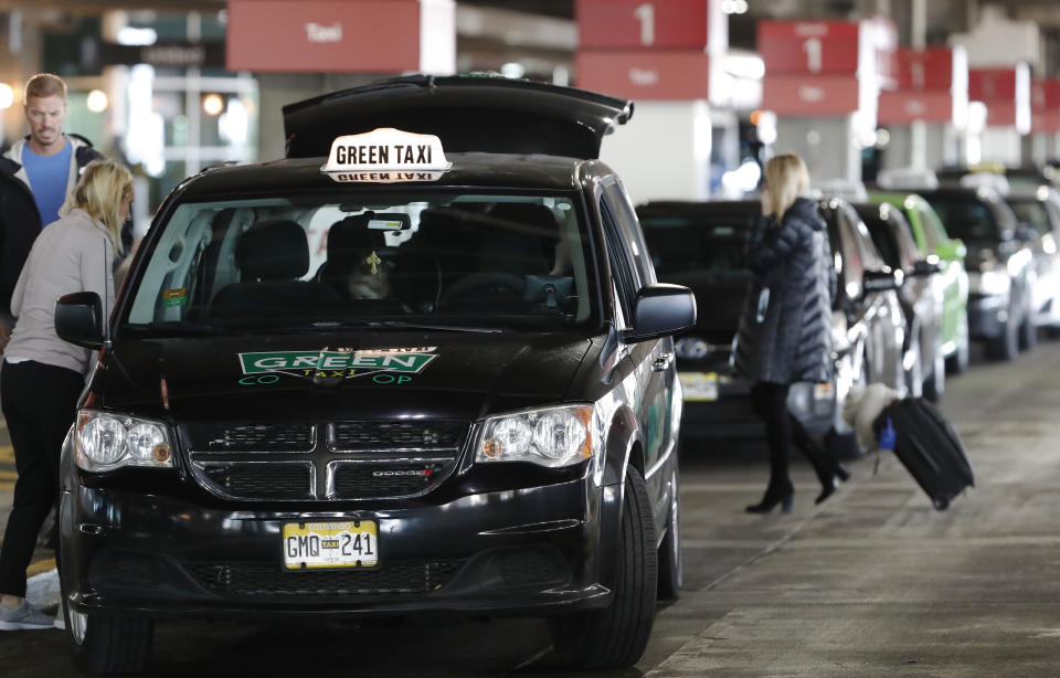 Travelers enter a cab at a cab stand in Denver International Airport Wednesday, Nov. 21, 2018, in Denver. Mild weather in parts of the country and lower gasoline prices have potentially created one of the busiest Thanksgiving Day travel periods since 2005, according to AAA. (AP Photo/David Zalubowski)