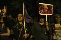 Kurdish women living in Cyprus shout slogans and hold a portrait of the Turkey's President Recep Tayyip Erdogan during a protest against Turkey's offensive into Syria, in Nicosia, Cyprus, Tuesday, Oct. 15, 2019. The protesters, waving Cypriot and Kurdish flags as well as placards pledging support for Syria's Kurdish population, chanted slogans condemning Turkey's military action and urged for the withdrawal of Turkish forces. (AP Photo/Petros Karadjias)