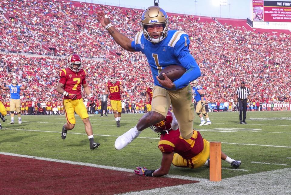 UCLA quarterback Dorian Thompson-Robinson scores a touchdown in front of USC linebacker Ralen Goforth.