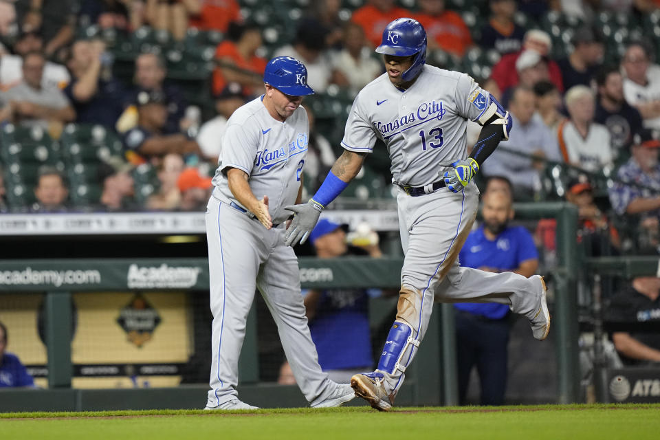 Kansas City Royals' Salvador Perez (13) celebrates with third base coach Vance Wilson after hitting a home run against the Houston Astros during the third inning of a baseball game Monday, Aug. 23, 2021, in Houston. (AP Photo/David J. Phillip)