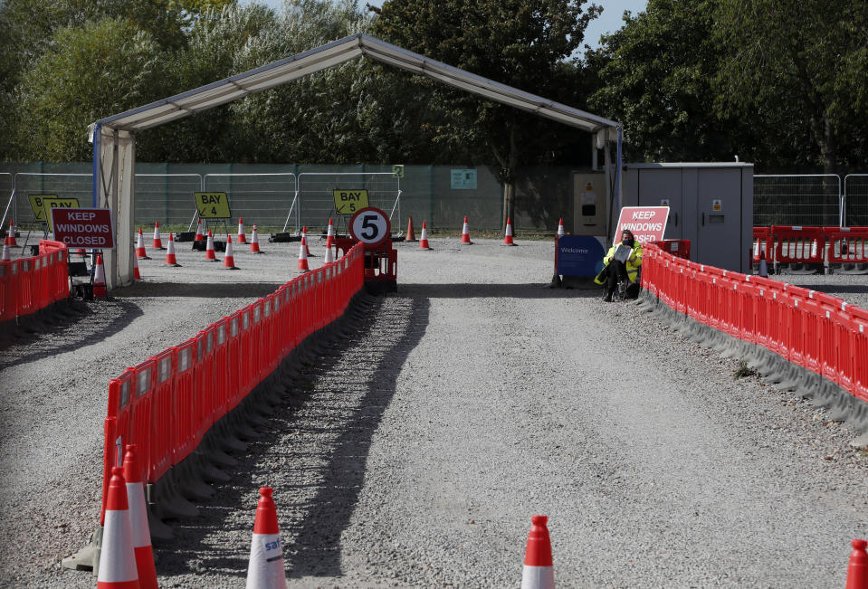 Staff waits beside the empty lanes of a Covid-19 drive thru testing facility at Twickenham stadium in London, Thursday, Sept. 17, 2020. Britain has imposed tougher restrictions on people and businesses in parts of northeastern England on Thursday as the nation attempts to stem the spread of COVID-19, although some testing facilities remain under-utilised. (AP Photo/Frank Augstein)