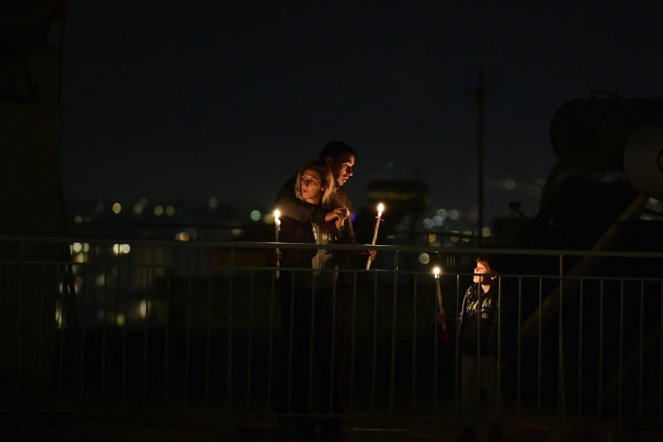 A family holding candles gather on a rooftop of a building during a lockdown order by the government to prevent the spread of the coronavirus in Athens, on Sunday, April 19, 2020. Greeks celebrated the Resurrection of Christ very differently Saturday night: confined at home, instead of massively congregating in churches. And they had to do without the "Holy Light" from Jerusalem, which arrived in Athens but was not distributed, as authorities remained ready to crack down on anyone who violated the strict curfew imposed almost a month ago. (AP Photo/Michael Varaklas)