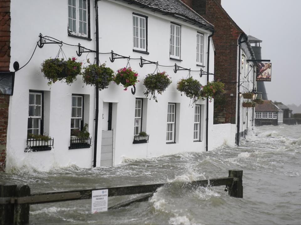 Sea water floods the shore line after high tide in Langstone, Hampshire (PA)