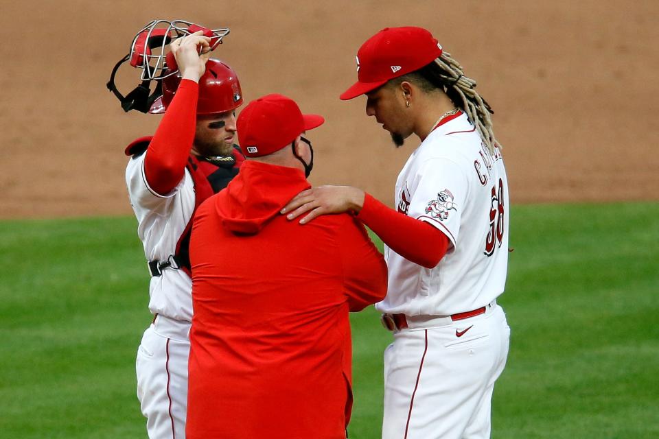 Cincinnati Reds starting pitcher Luis Castillo (58) is visited at the mound by catcher Tucker Barnhart (16) and pitching coach Derek Johnson in the third inning of the MLB National League game between the Cincinnati Reds and the Arizona Diamondbacks at Great American Ball Park in downtown Cincinnati on Tuesday, April 20, 2021. The Diamondbacks led 3-2 after five innings. 