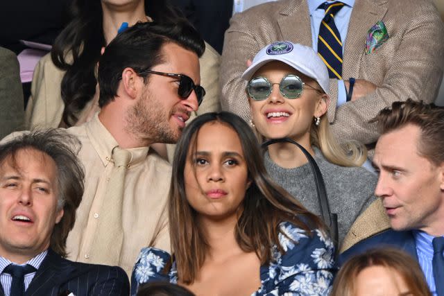 <p>Karwai Tang/WireImage</p> Ariana Grande is all smiles at Wimbledon alongside Jonathan Bailey.