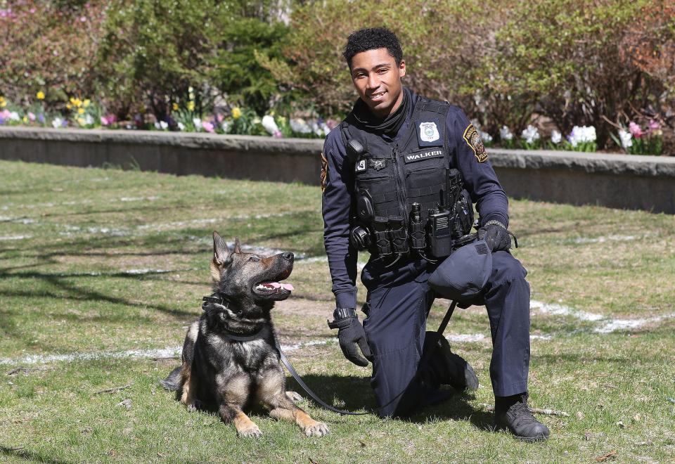 Brookline, Massachusetts, Police K9 Officer Will Walker poses for a portrait with Kemba outside Brookline Town Hall on April 9, 2021.