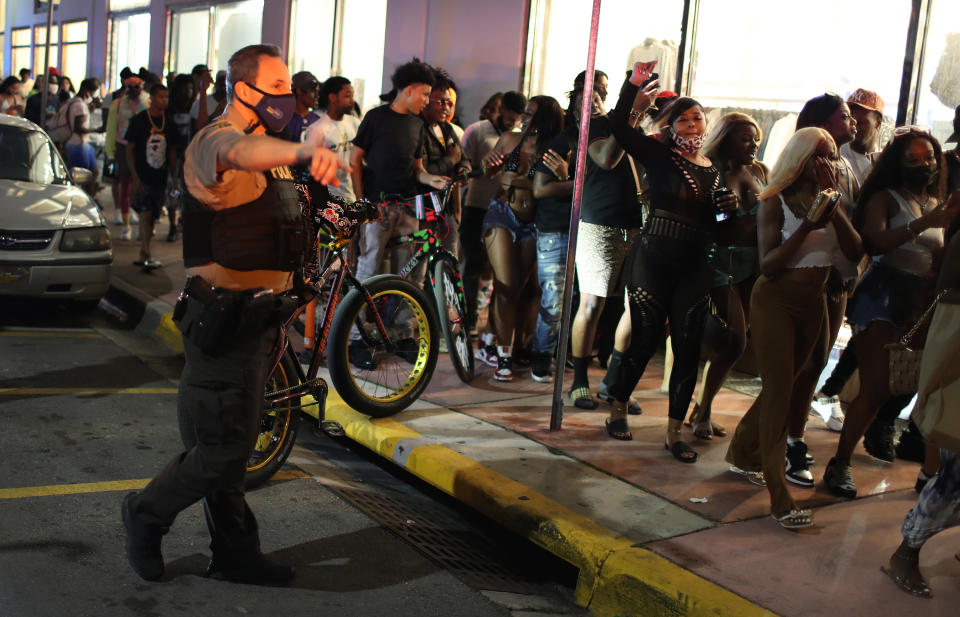 MIAMI BEACH, FLORIDA - MARCH 21: A Miami Dade police officer directs people out of the area as an 8 pm curfew goes into effect on March 21, 2021 in Miami Beach, Florida. College students have arrived in the South Florida area for the annual spring break ritual, prompting city officials to impose an 8pm to 6am curfew as the coronavirus pandemic continues. Miami Beach police have reported hundreds of arrests and stepped up deployment to control the growing spring break crowds. (Photo by Joe Raedle/Getty Images)