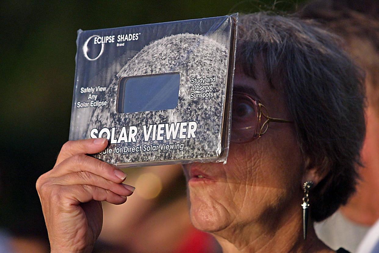 2001: A woman  observes a solar eclipse through a protective shield in Puntarenas, Costa Rica. 