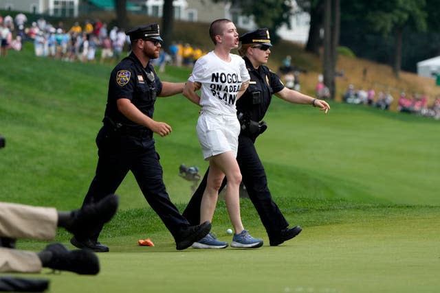 A protester is led away by two police officers