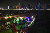 People dance in a wooden boat at the Corniche sea promenade in Doha, Qatar, Friday, Nov. 18, 2022. Pearl fishing drove Qatar's economy until the 1930s. The dangerous, seasonal trade employed nearly all the former British protectorate's young men and many slaves. But the market collapsed in the early 20th century with the Japanese invention of artificial pearls. (AP Photo/Francisco Seco)